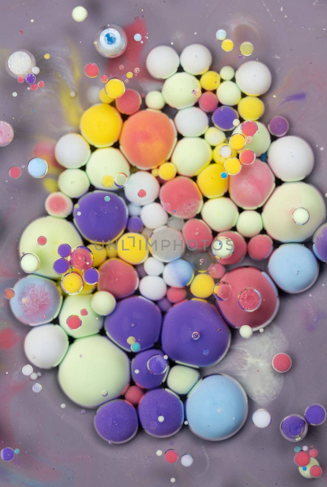 A close-up photograph showcasing a mesmerizing array of colorful bubbles suspended in a liquid medium, creating a stunning abstract composition. The bubbles exhibit a vibrant spectrum of hues.
