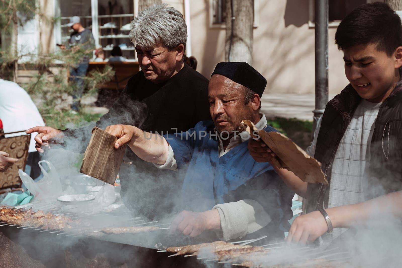 SHYMKENT, KAZAKHSTAN - MARCH 22, 2023: a kazakh man cooking barbecue for celebration of Nauryz