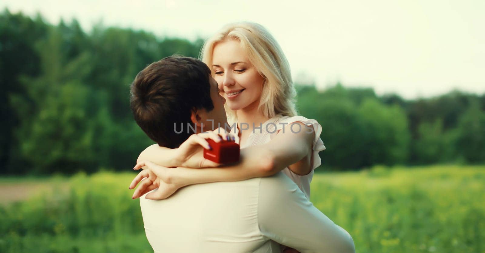 Wedding happy lovely young couple, man proposing a ring to his beloved woman outdoors in summer park by Rohappy