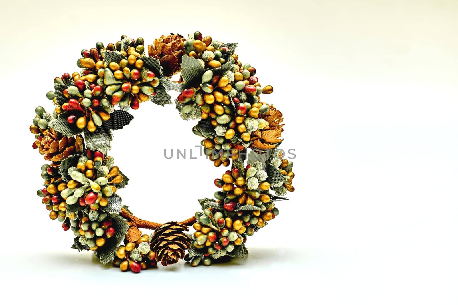 Artificial green brown wreath with leaves cones berries isolated on white by jovani68