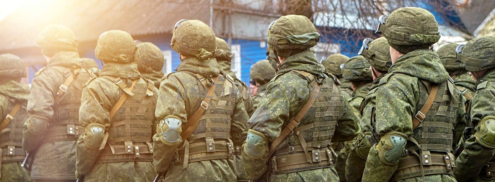 Disciplined soldiers in camouflage march in perfect synchronization during a military parade. Helmets and rifles add to the display of unity and strength, evoking pride.