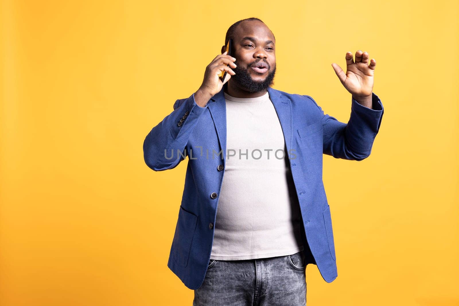 Joyous man with positive emotion, enjoying talking with friends phone call using smartphone, studio background. Happy person with smile on face, receiving good news during telephone call