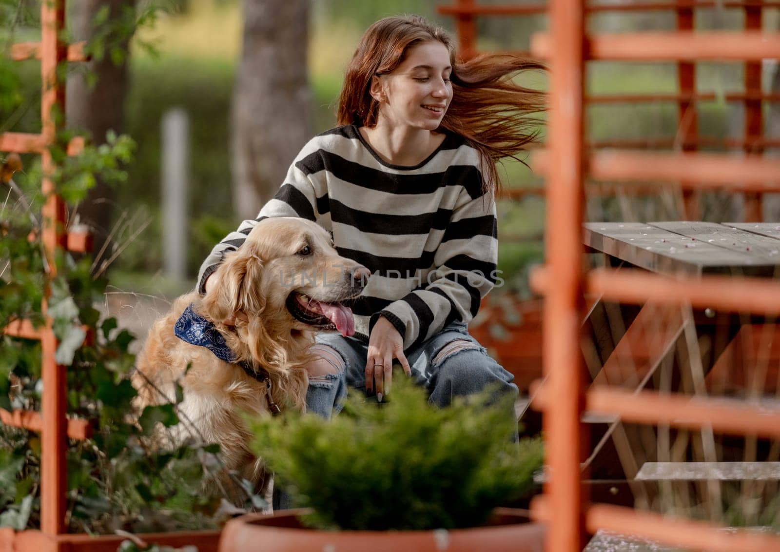 Teen Girl Plays With Golden Retriever In Gazebo During Spring