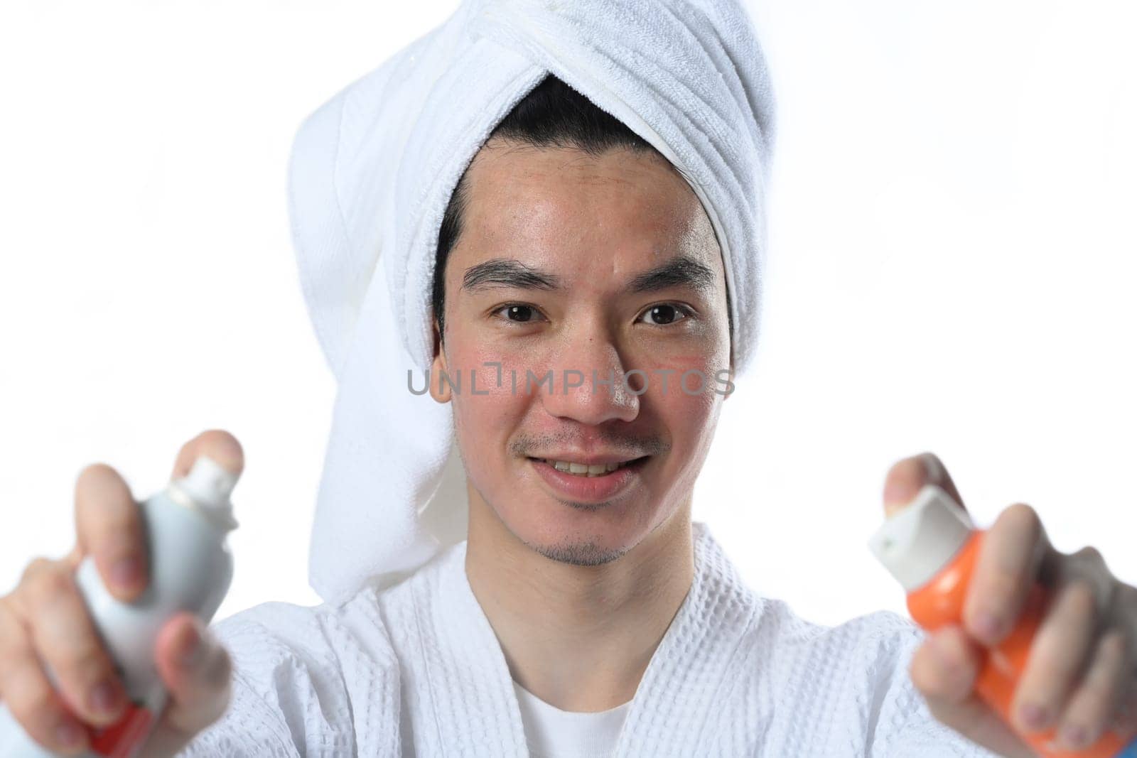 Young man applying sunscreen after laser treatment. UV protection and aesthetic face treatment concept.