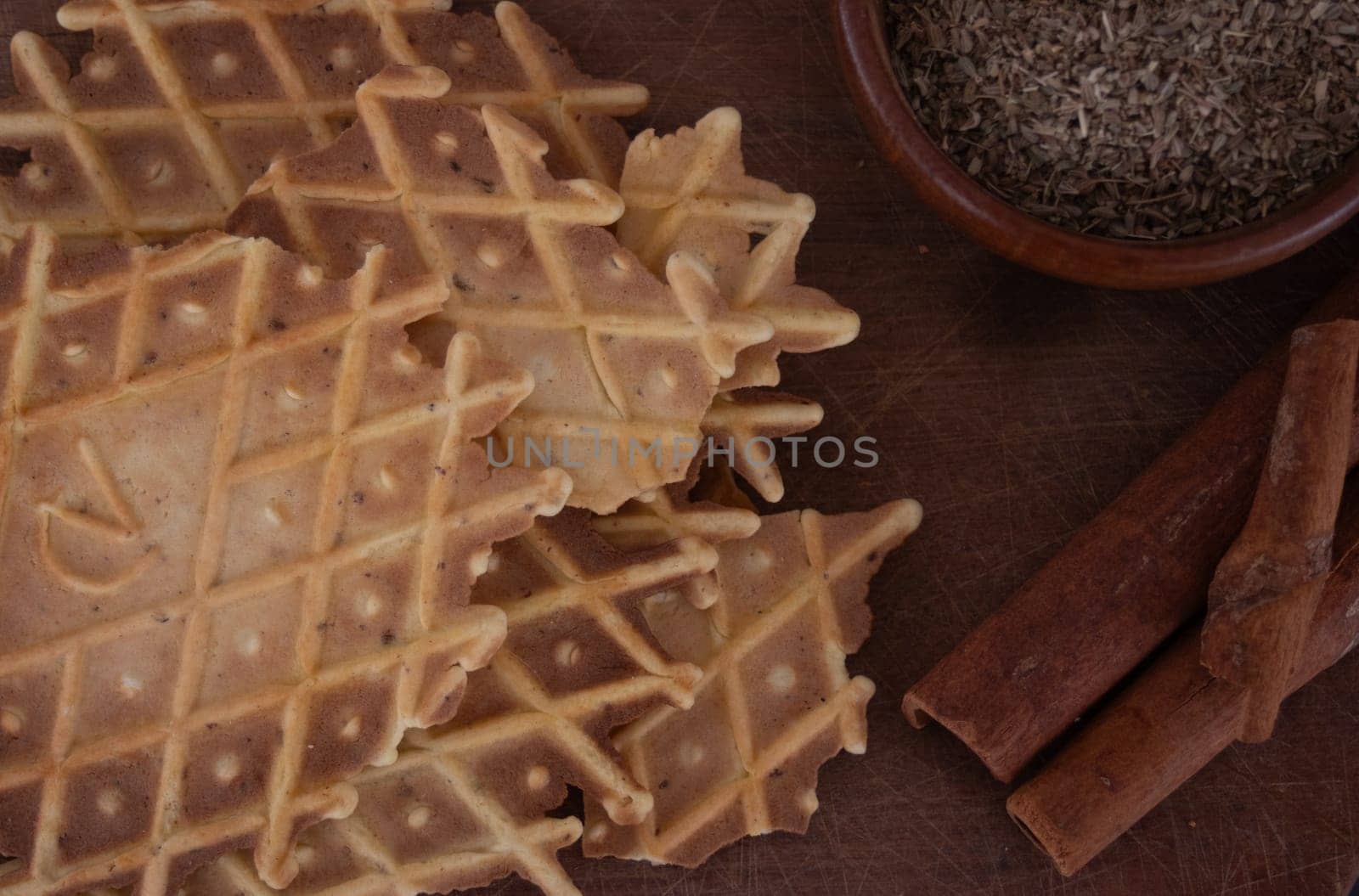 Delicious crunchy cinnamon biscuit. Dark background.Still life. Wooden bowl with anise seeds and cinnamon sticks