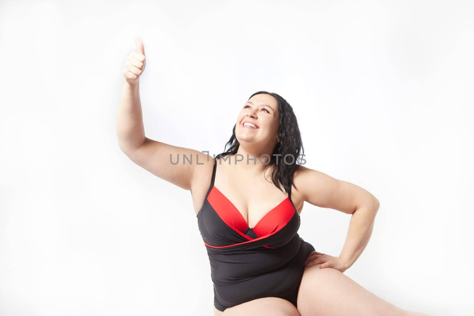 Happy attractive thick woman in swimsuit posing on white background. Body positive, photoshoot, selfie. Funny plus size model, Winner in Weight loss