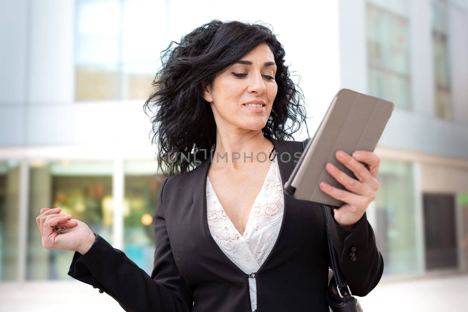 Smiling caucasian businesswoman with digital tablet outdoors. by mariaphoto3