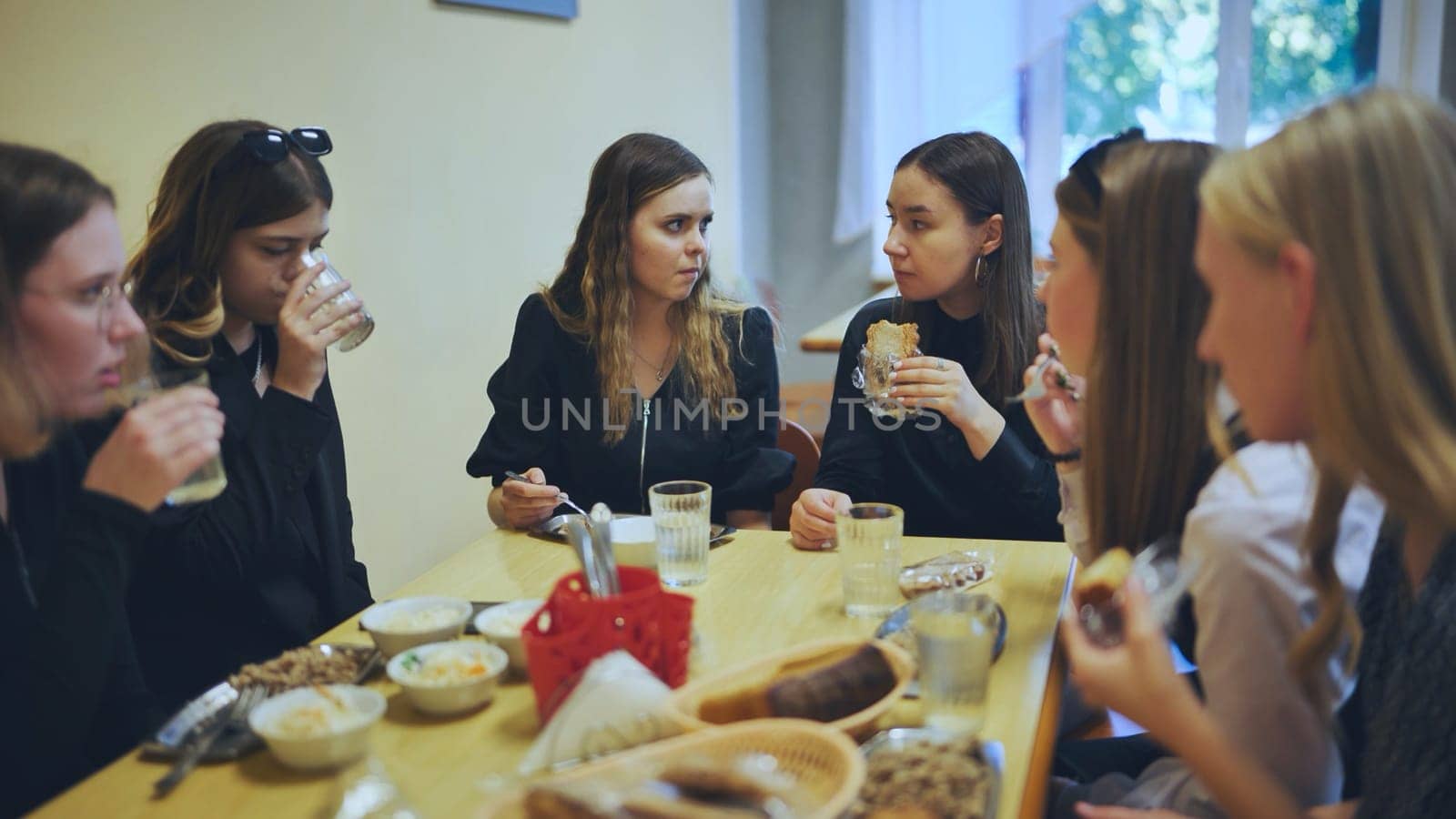 High school students eat in the cafeteria. by DovidPro