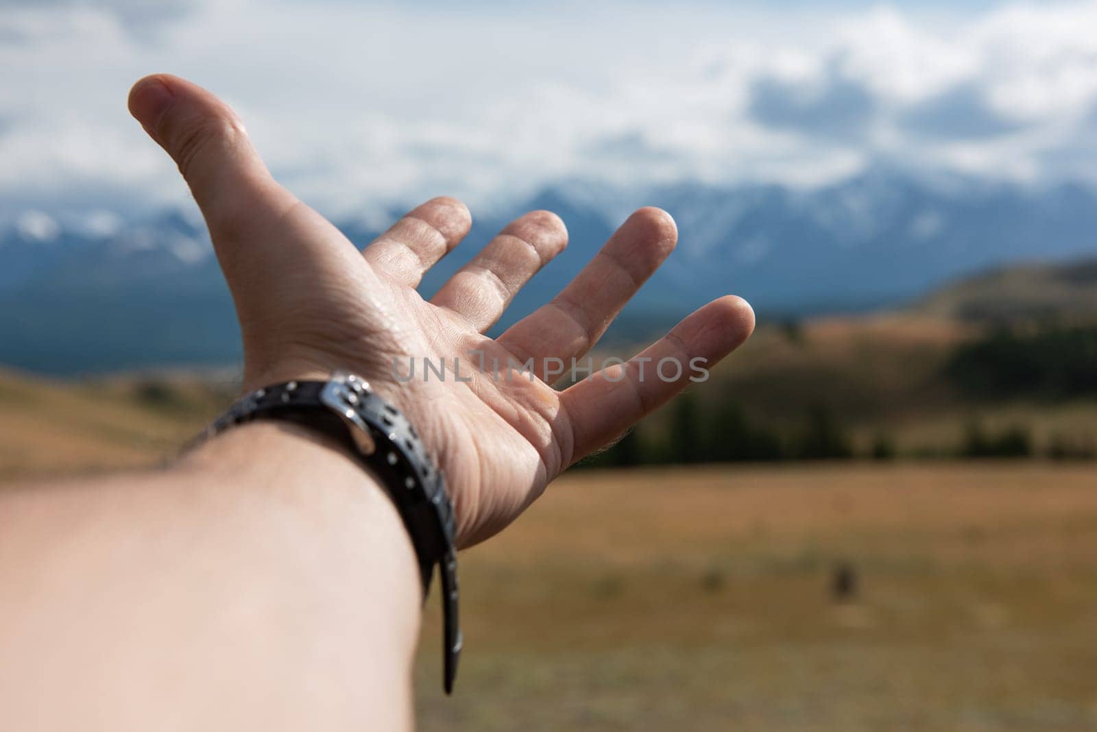 Close up of male traveler hand in auto relaxing and enjoying road trip in Altai mountains Summer vacation and road trip concept.