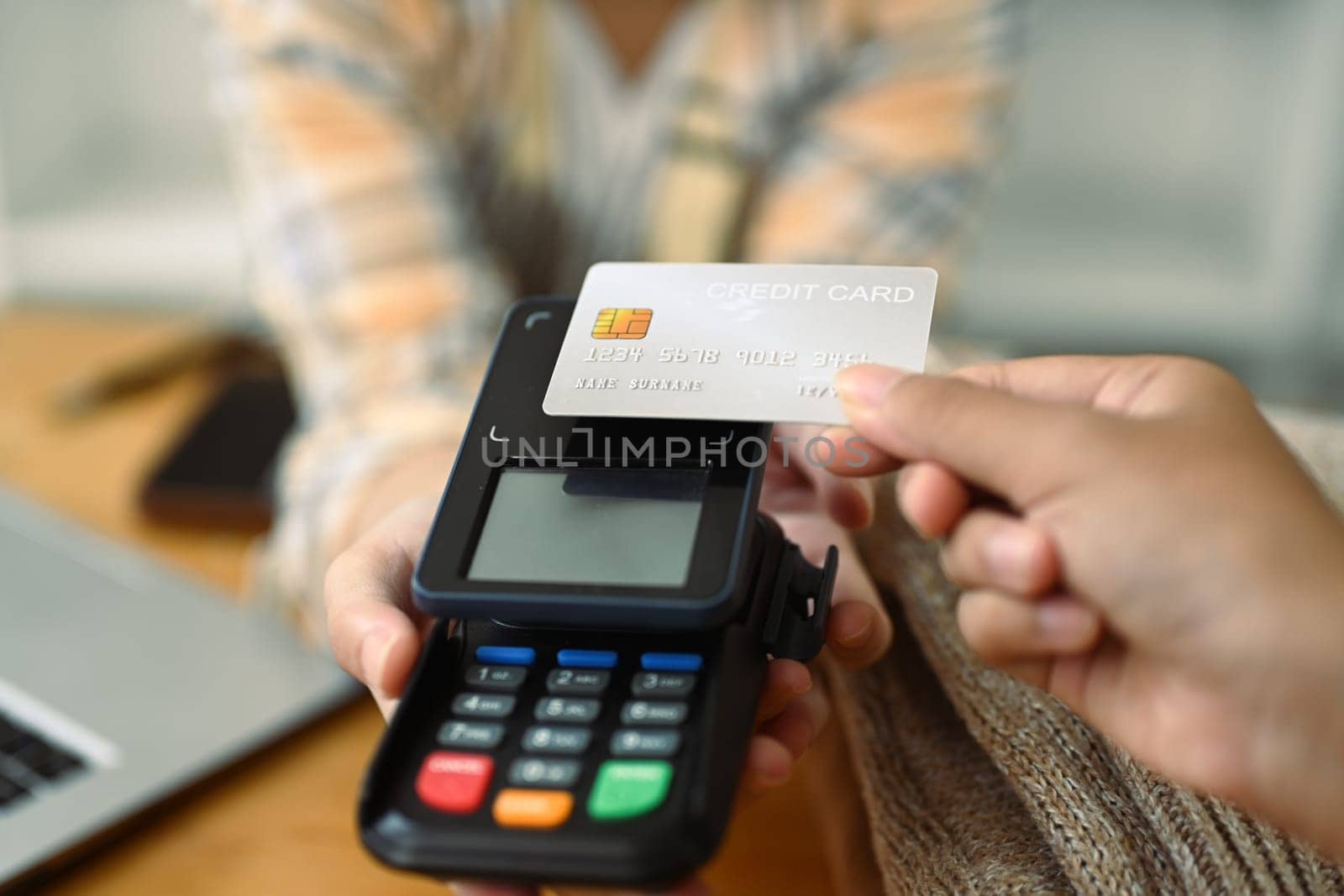 Close up customer paying with cashless technology with credit card at coffee shop.