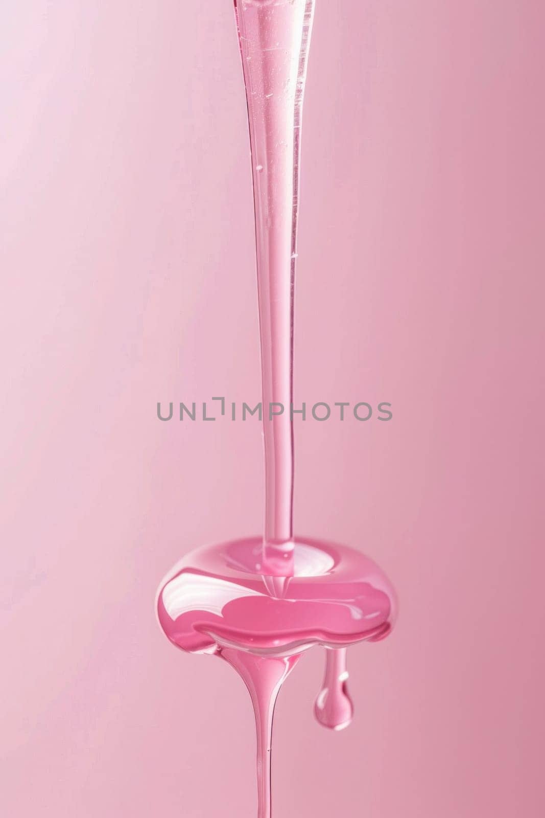 Pink liquid dripping from glass on pink background, beauty and art concept with copy space