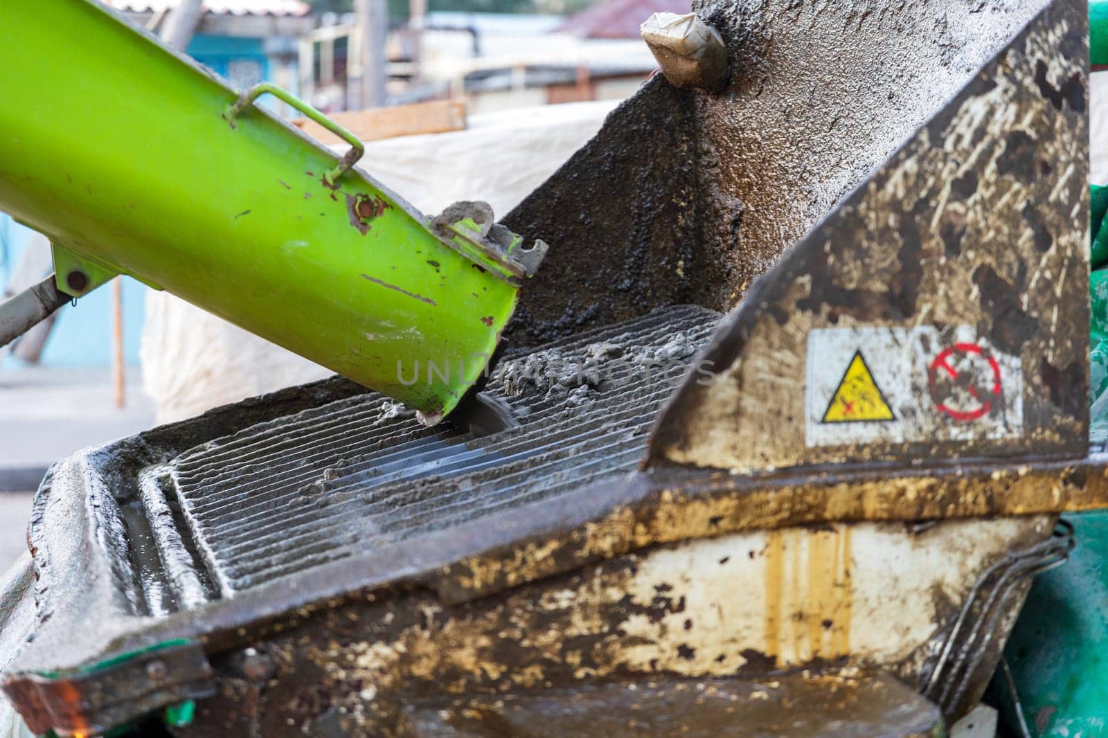 Straining concrete from large fractions for a concrete pump truck, close-up.