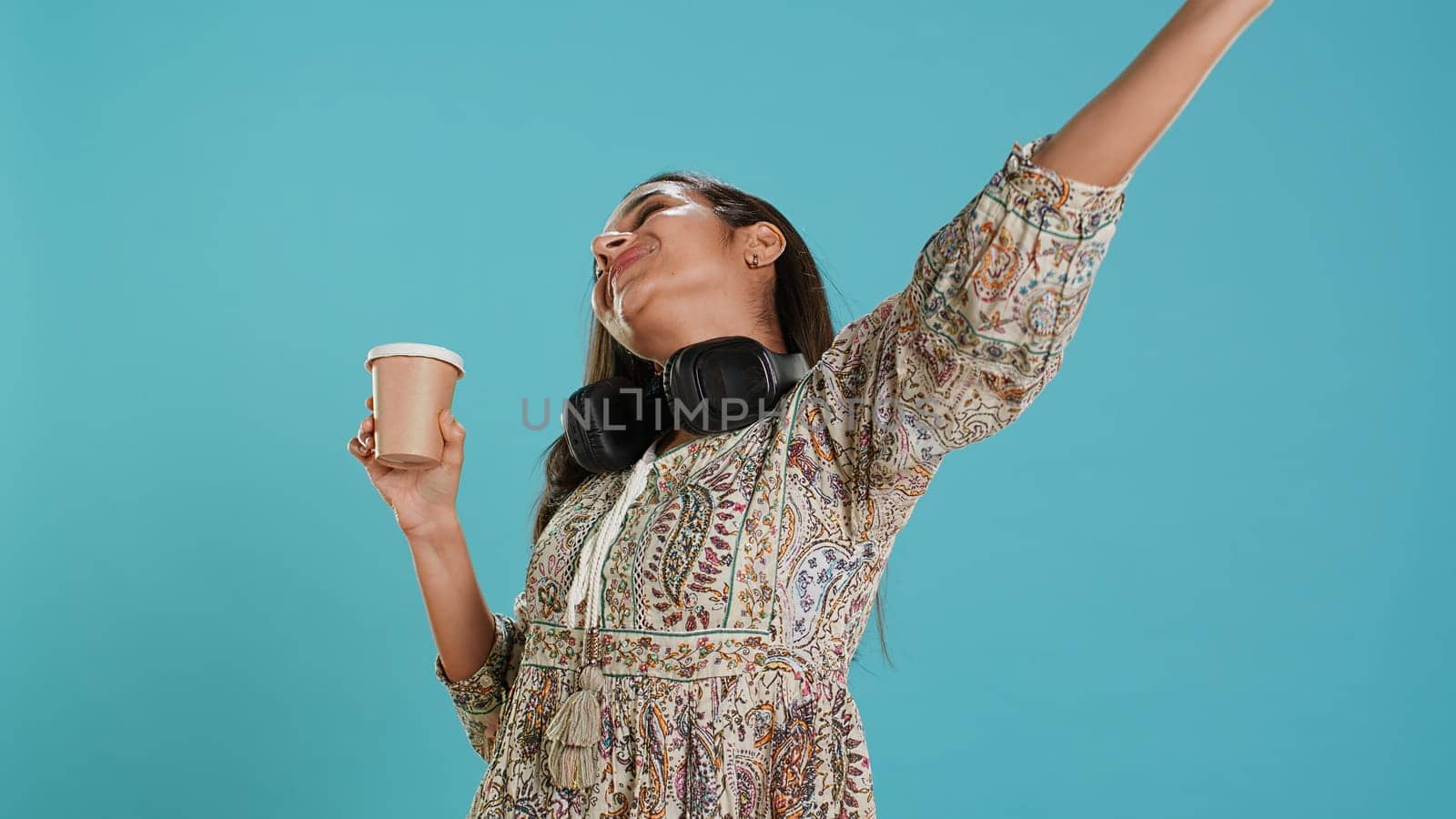 Joyful woman stretching and sipping coffee after waking up by DCStudio