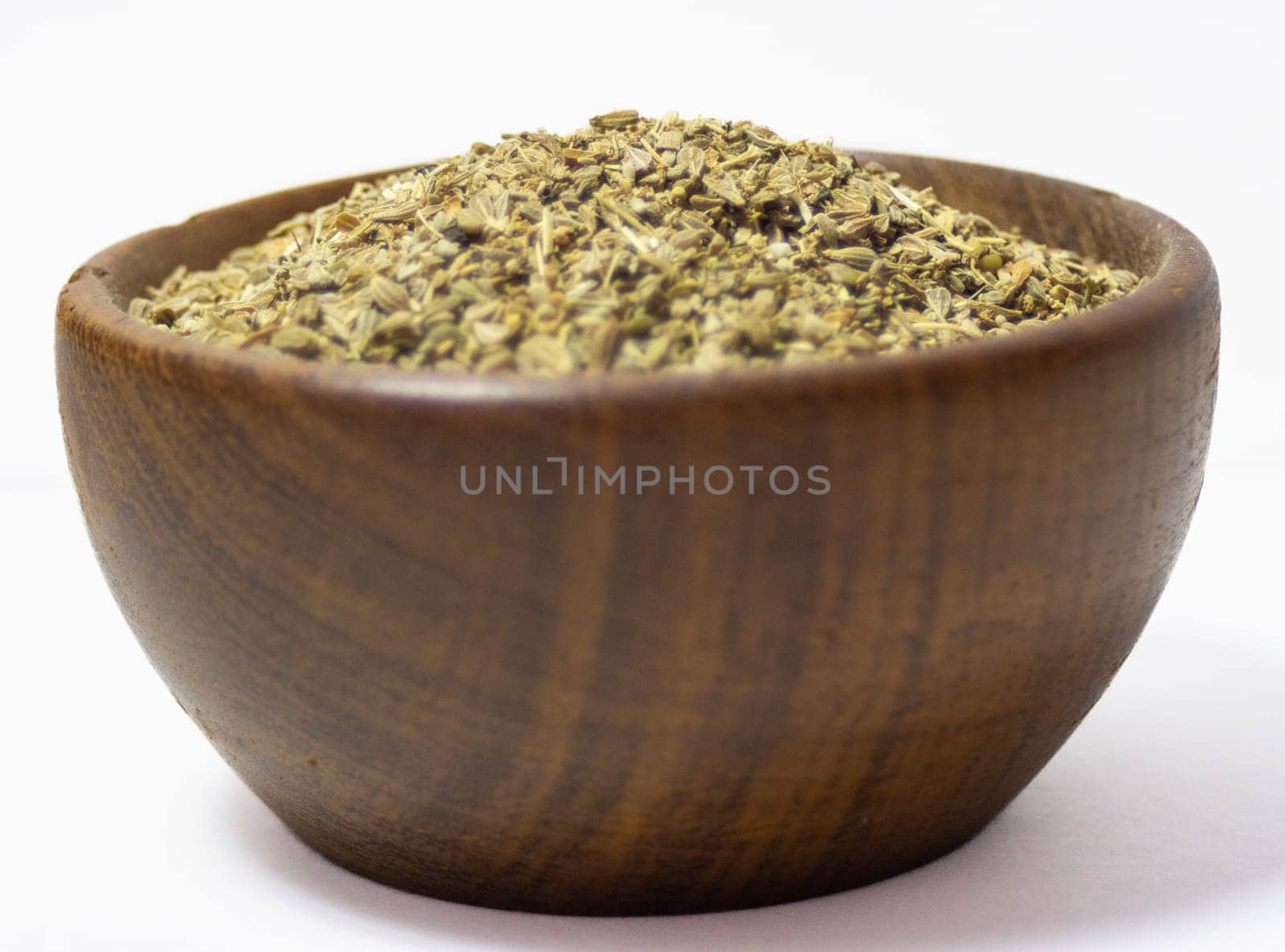 A rustic bowl with anise seeds with white background. Healthy seeds concept by VeroDibe