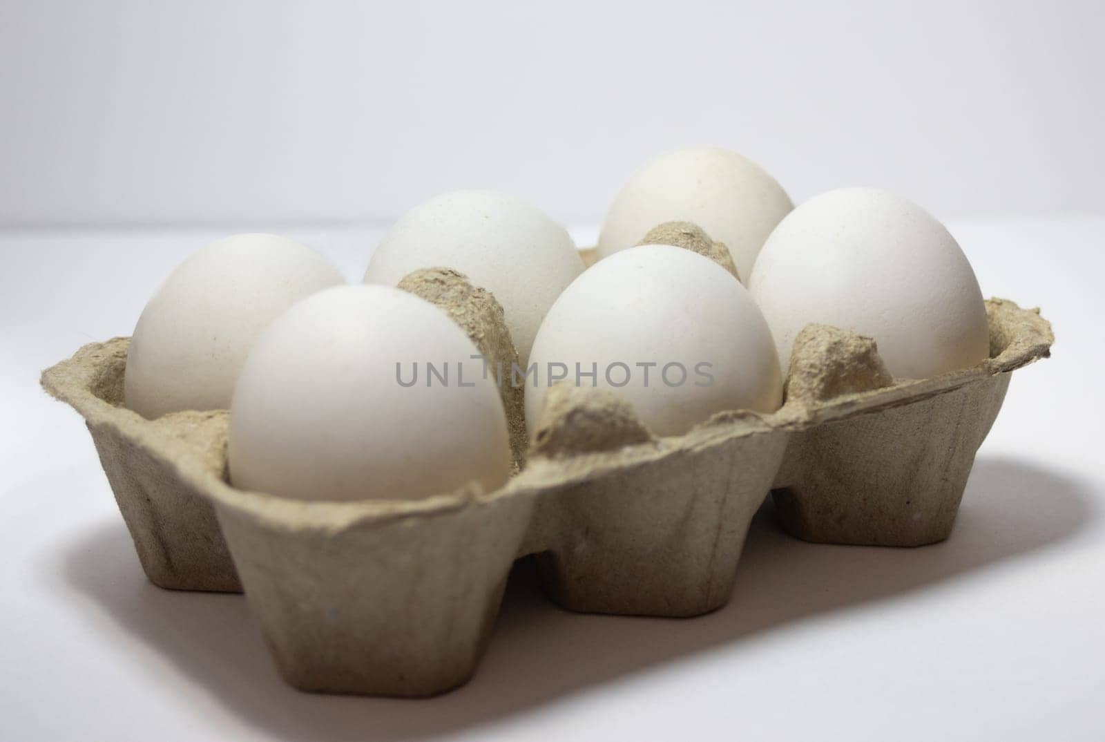 Half a dozen white eggs in a pack.,isolated ,on white background by VeroDibe