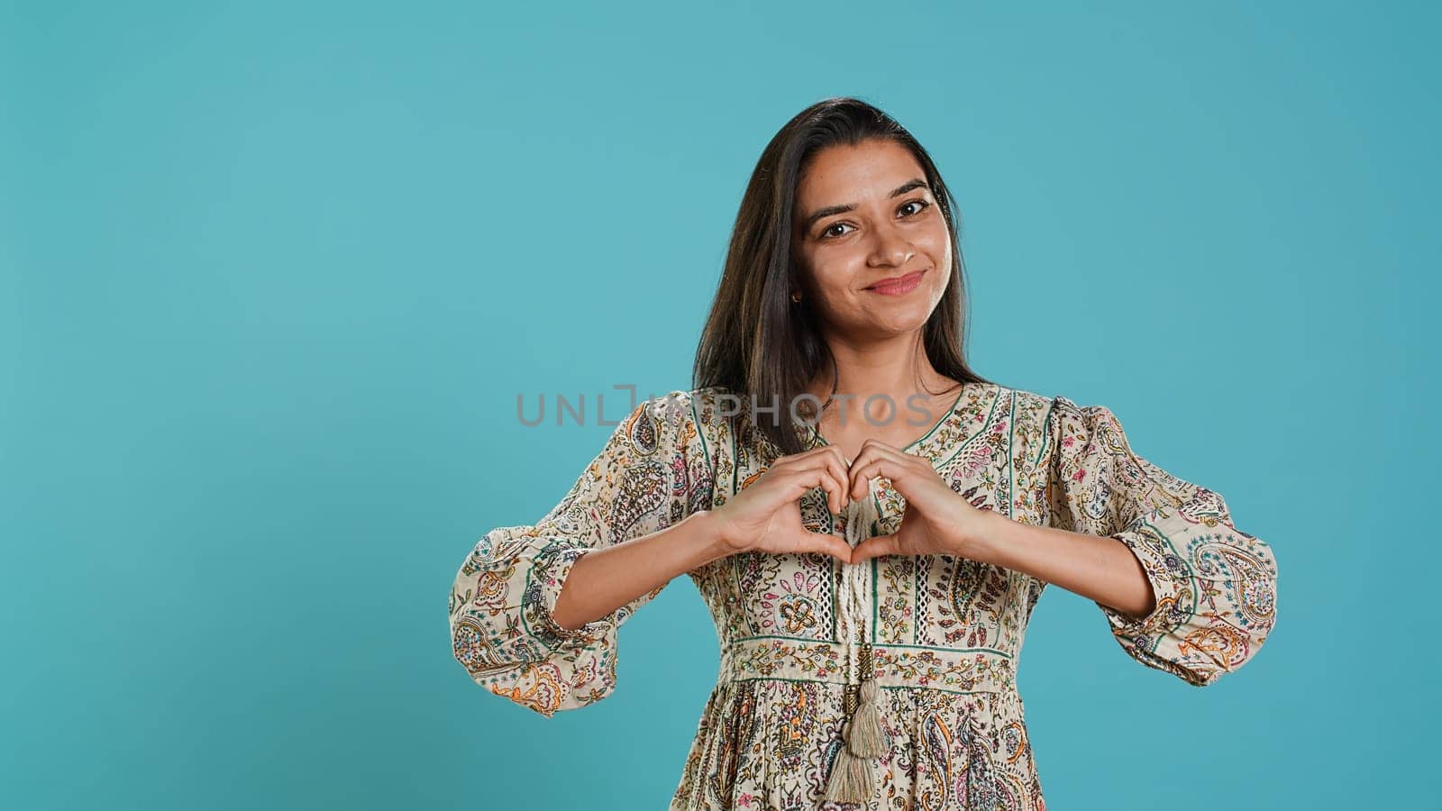 Portrait of jolly friendly woman doing heart symbol shape gesture by DCStudio