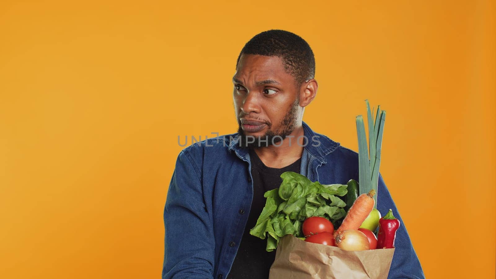 Young person staying in line at the local farmers market and talking to clients, advocating for zero waste sustainable lifestyle. Vegan guy supporting local farming, healthy eating. Camera A.