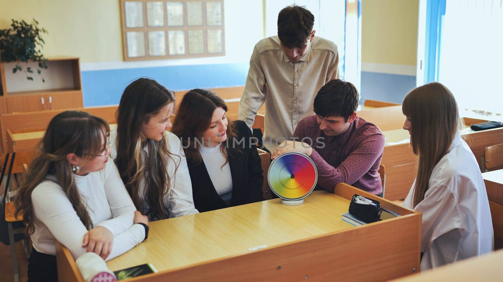 Students in physics class spin Newton's multicolored disk