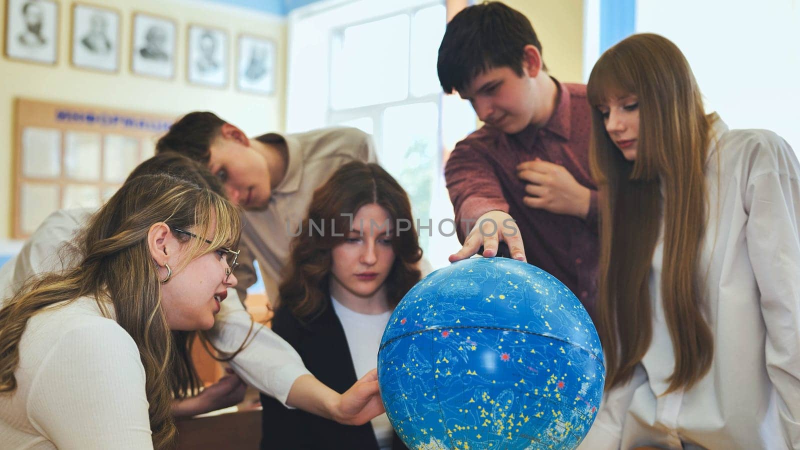 Students look at a globe of the starry sky in a classroom at school