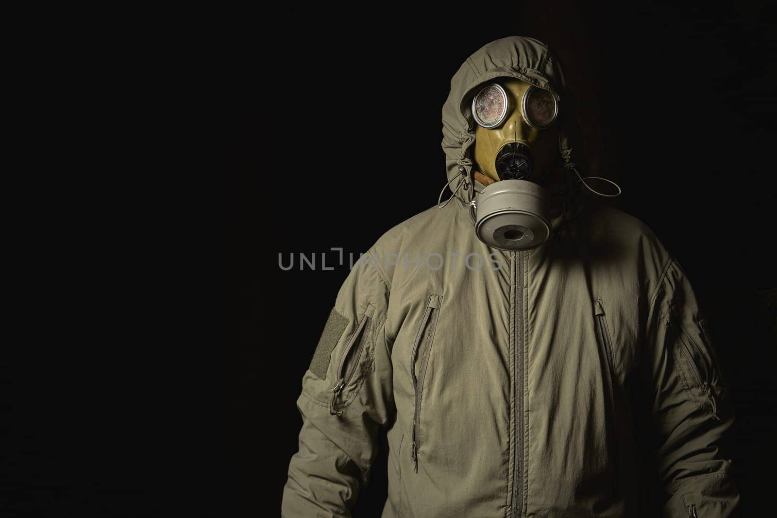 man in a gas mask protects himself from coronavirus at night