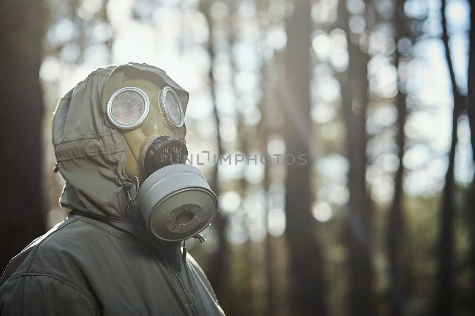 man in a gas mask protects himself from coronavirus in the woods