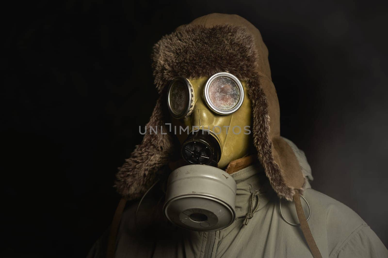 man in a gas mask protects himself from coronavirus at night