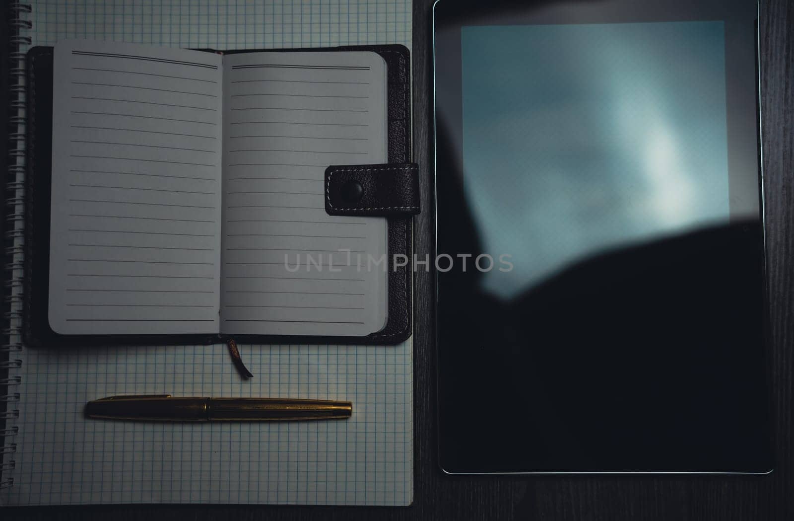 Workplace. Notebook with pen and tablet on a wooden table. Strict style. High quality photo