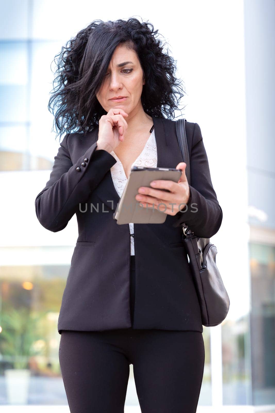 Vertical portrait serious caucasian businesswoman with digital tablet outdoors. by mariaphoto3