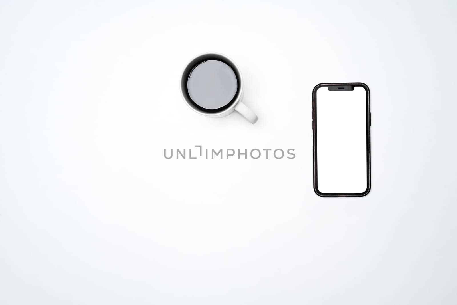 A cup of coffee and smartphone with blank screen isolated on white background.