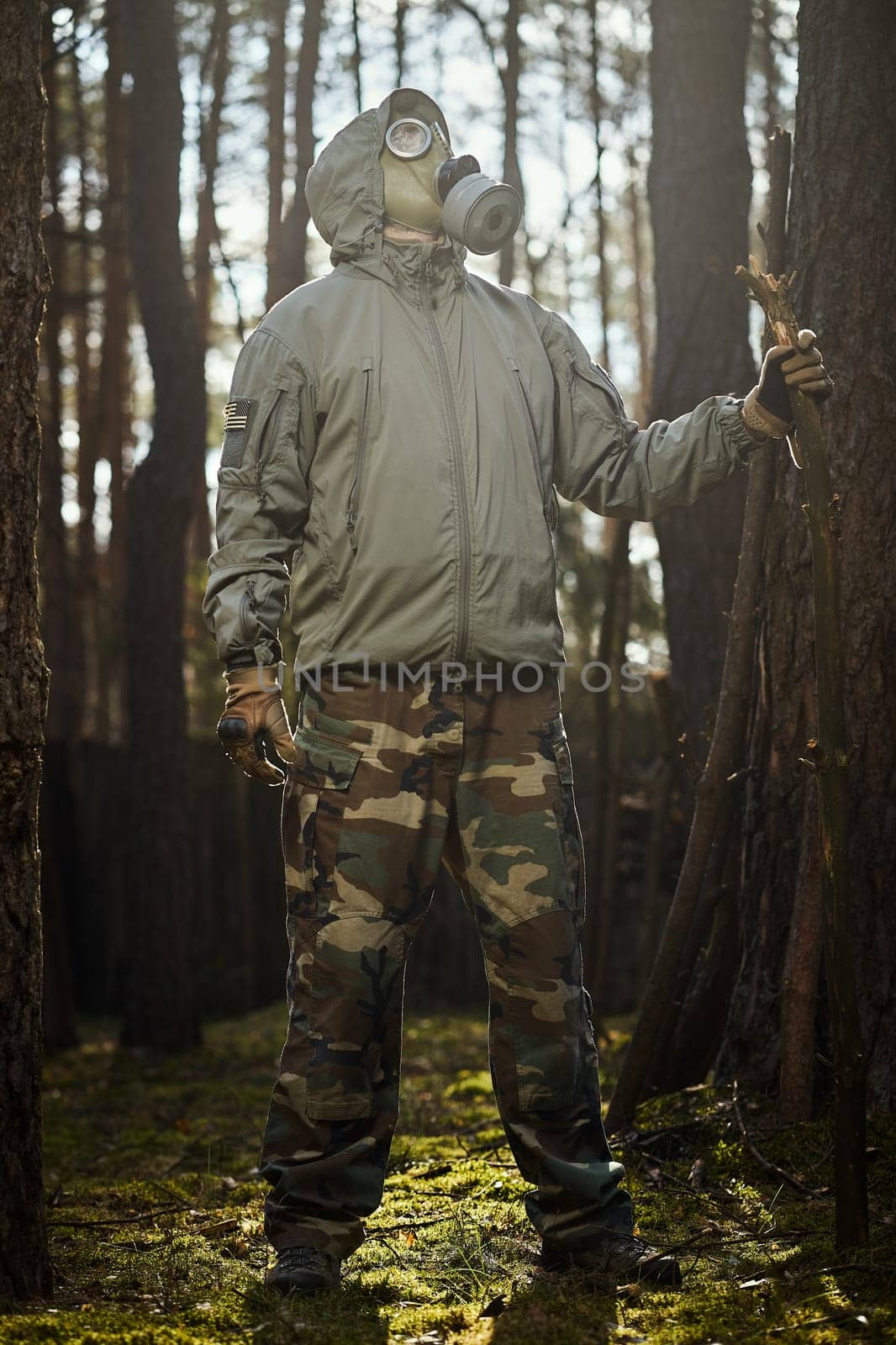 man in a gas mask protects himself from coronavirus in the woods