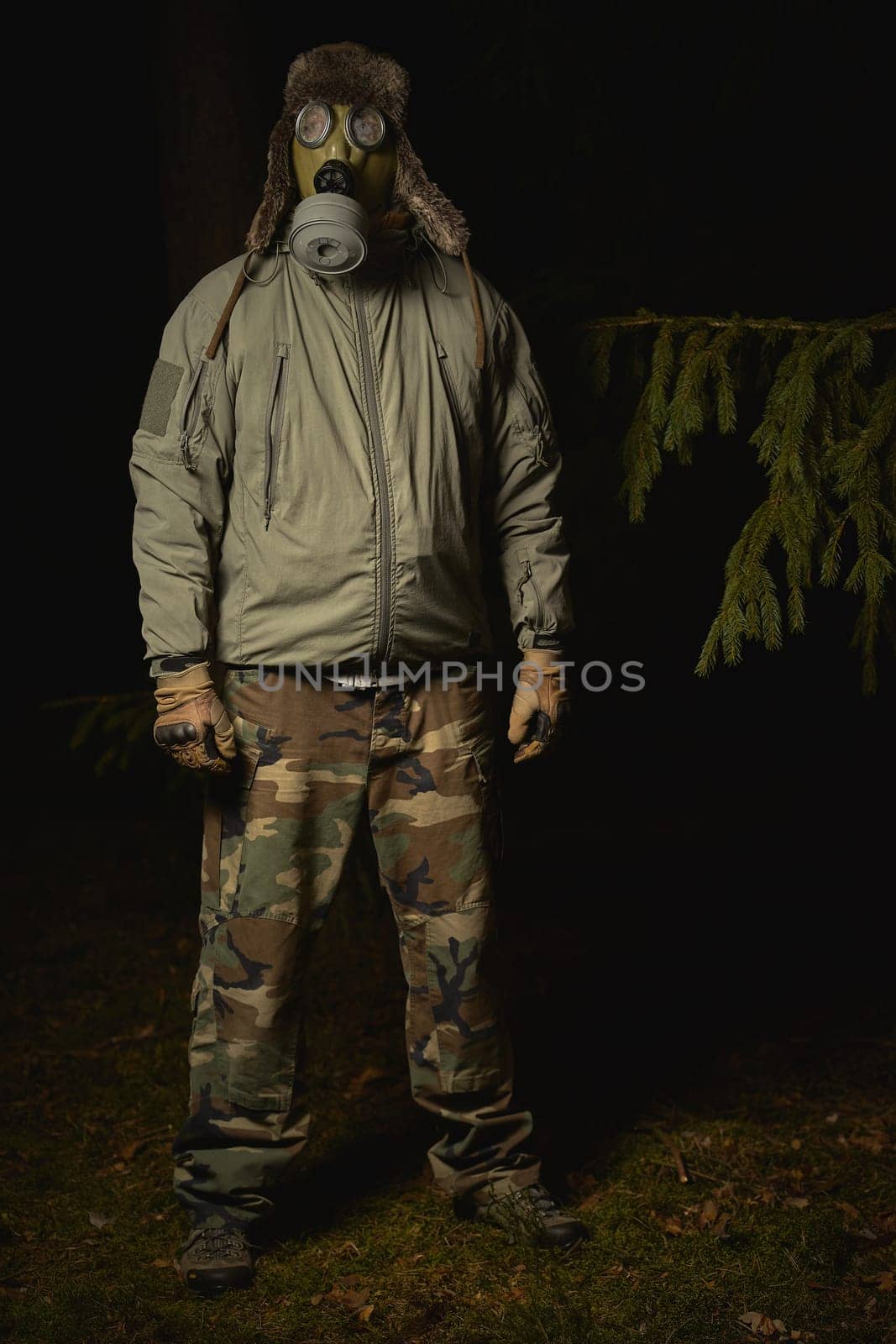 man in a gas mask protects himself from coronavirus at night