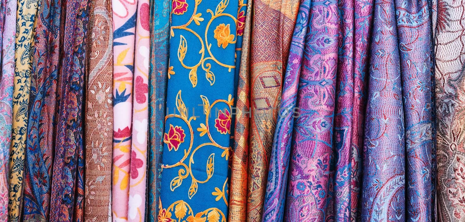 Traditional silk Uzbek scarves with colorful pattern at oriental bazaar in Tashkent in Uzbekistan close-up by alexkoral