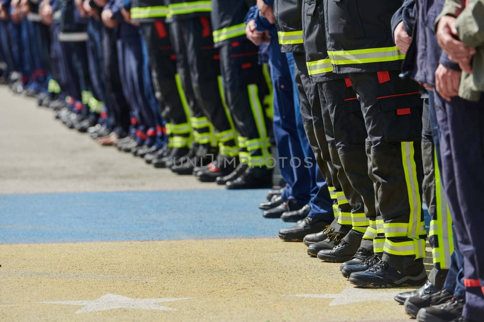 A group of firefighters lined up, saluting the flag, applauding in solidarity, and gearing up for intensive training sessions, showcasing their unwavering commitment to service and teamwork