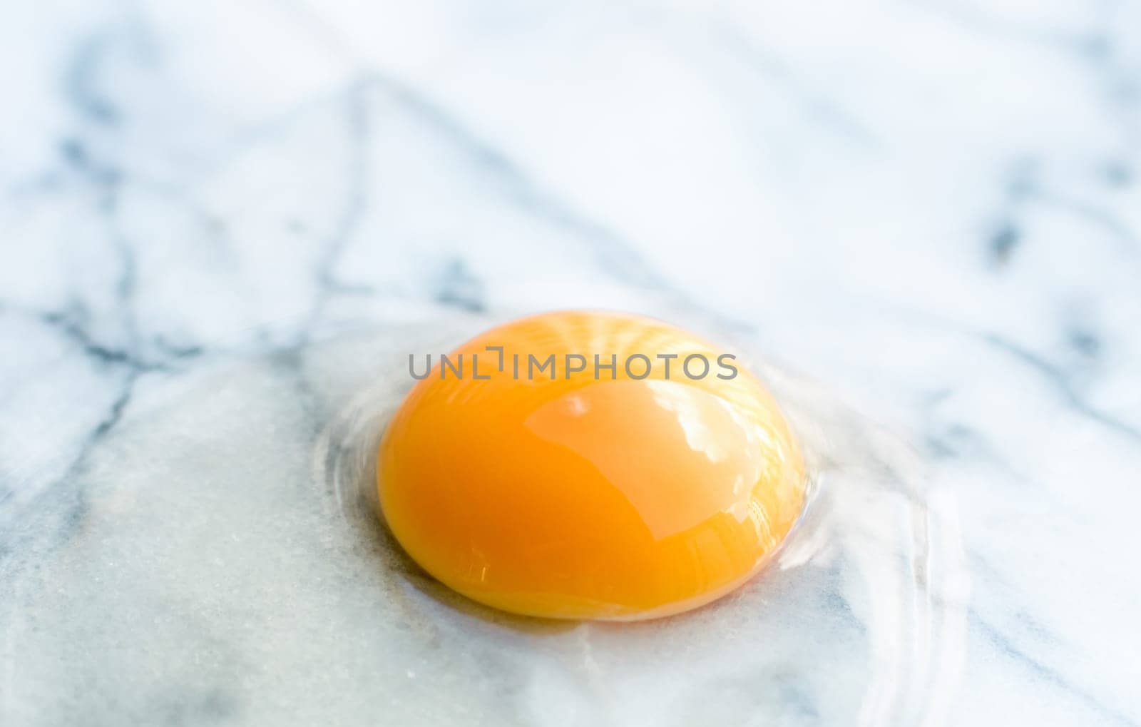 egg yolk on marble - recipe ingredients and homemade cooking concept by Anneleven