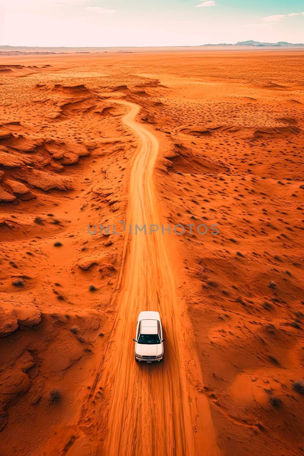 A white car is driving down a dirt road in a desert. The road is narrow and winding, and the landscape is barren and dry. The car is the only object in the scene