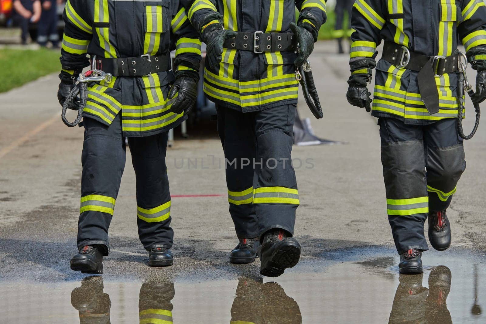 A team of confident and accomplished firefighters strides purposefully in their uniforms, exuding pride and satisfaction after successfully completing a challenging firefighting mission.