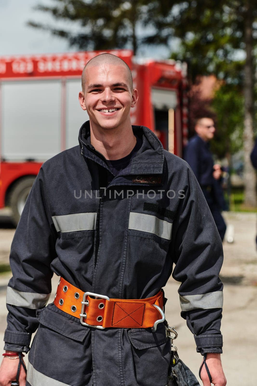 Firefighter Stands Proudly with Professional Gear Beside Fire Truck After Intense Training by dotshock