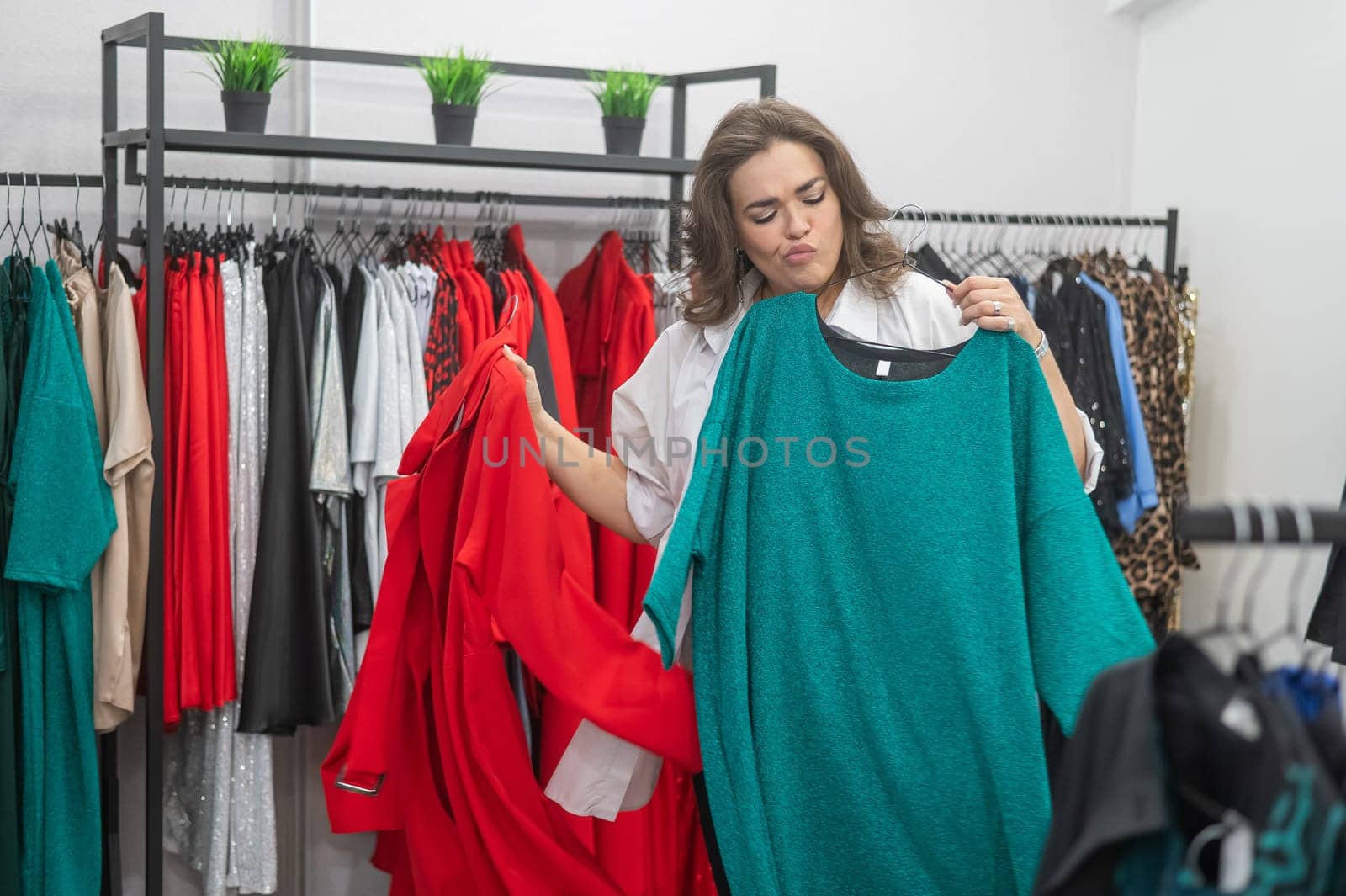 A fat woman chooses clothes in a plus size store. by mrwed54