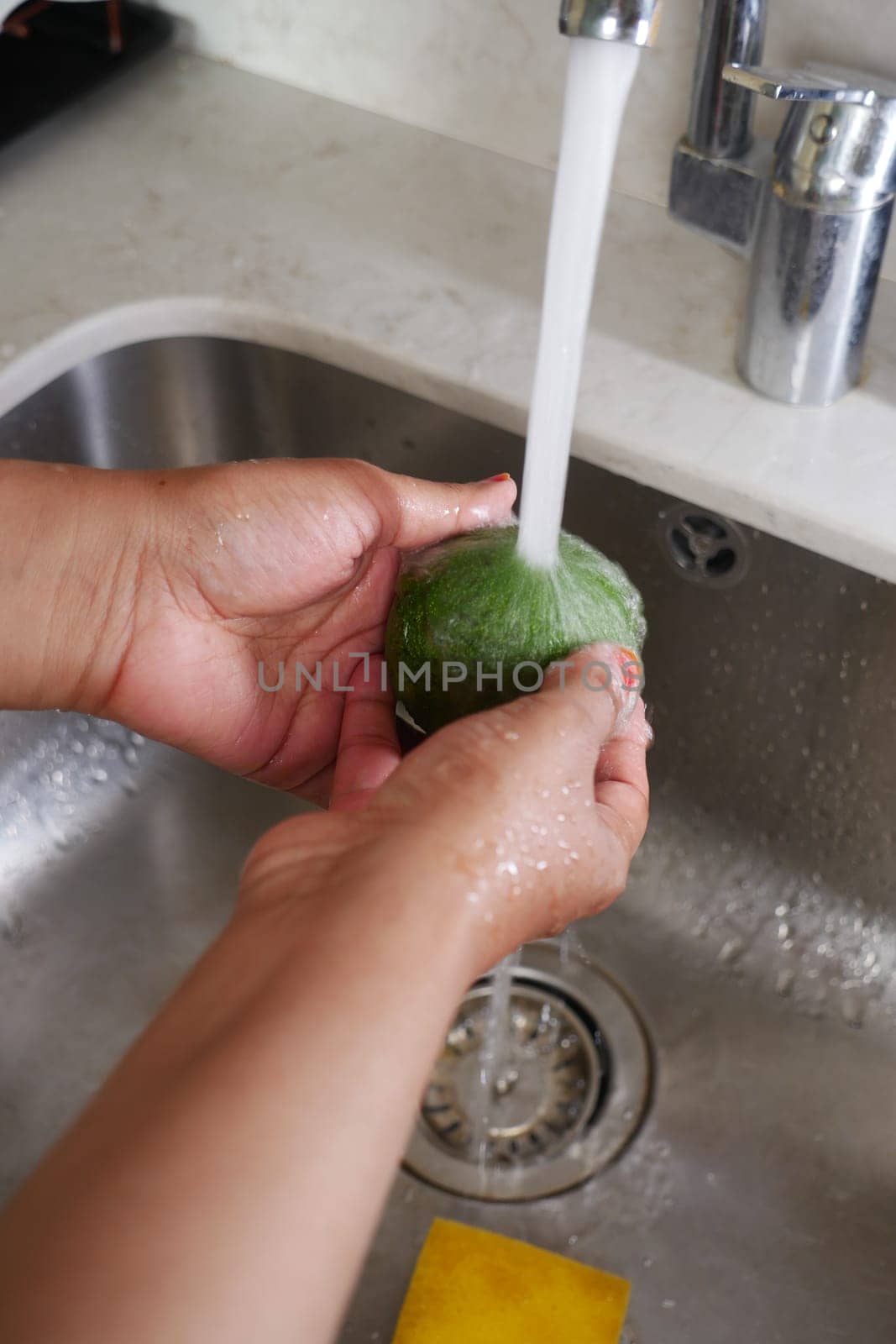 hand washing avocado with water sprinkling.