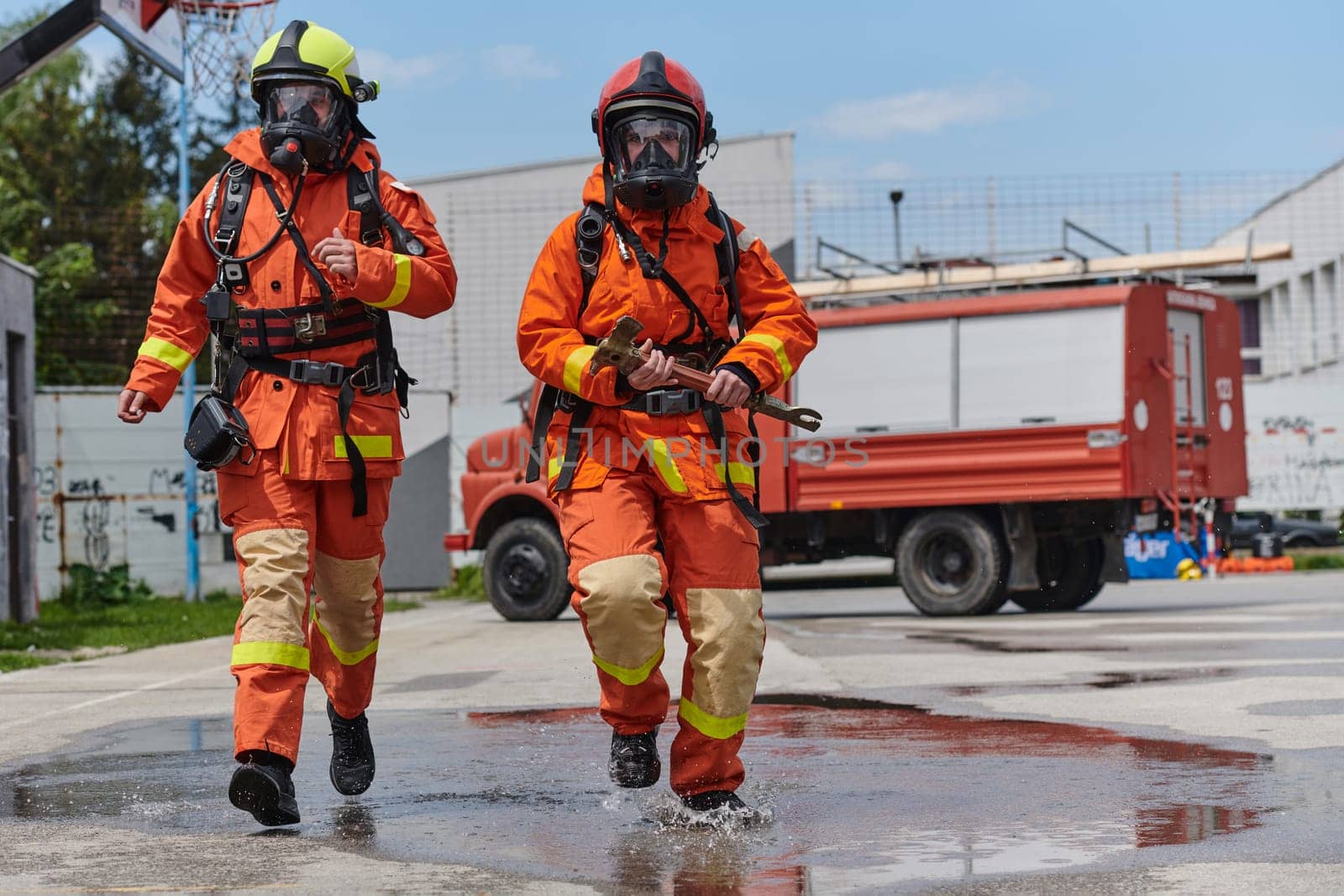 A team of firefighters, dressed in professional gear, undergoes training to learn how to use various firefighting tools and prepare for firefighting tasks.