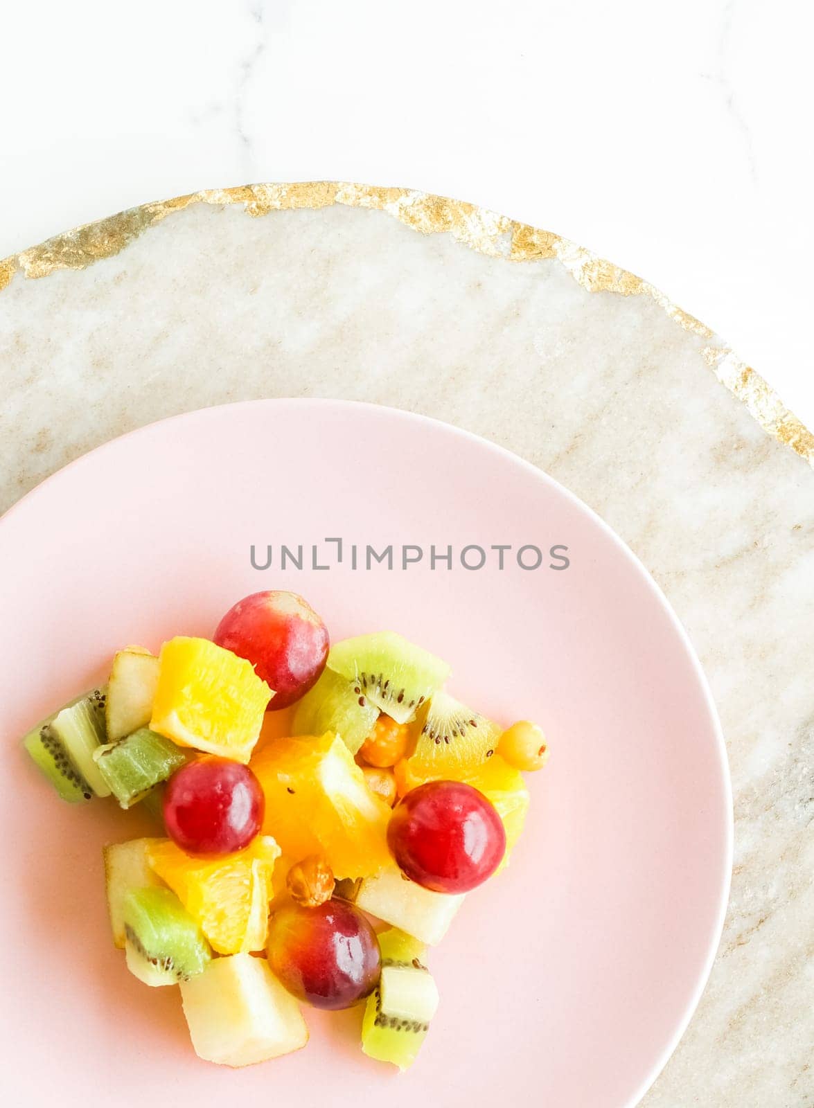 juicy fruit salad for breakfast on marble, flatlay - dieting and healthy lifestyle concept by Anneleven