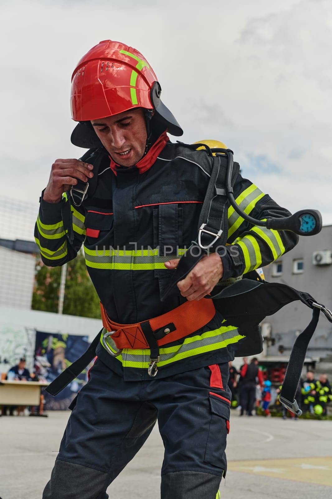 A professional firefighter dons his protective gear, preparing to respond to an emergency call.