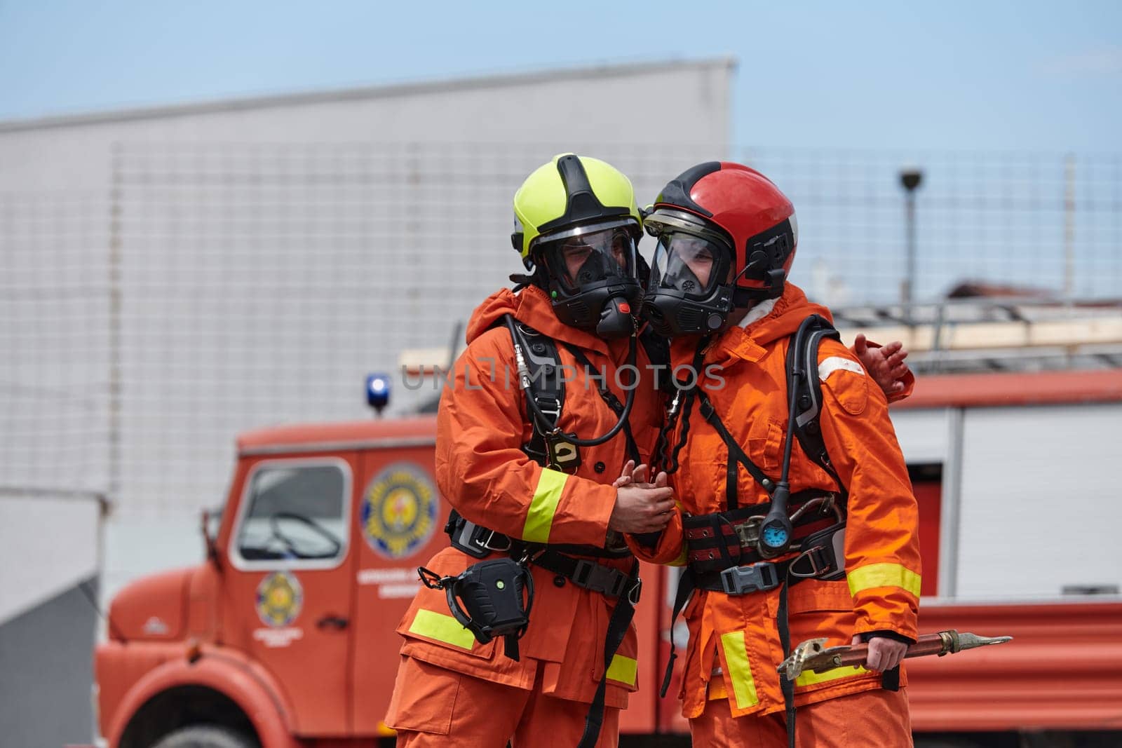 A unified team of firefighters, adorned in their uniforms, engages in a heartfelt celebration marked by triumphant salutes and cheers, embodying the joy and gratitude following the successful completion of a challenging firefighting mission.