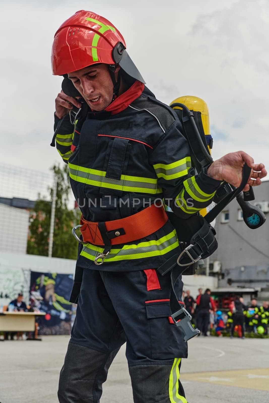 A professional firefighter dons his protective gear, preparing to respond to an emergency call.