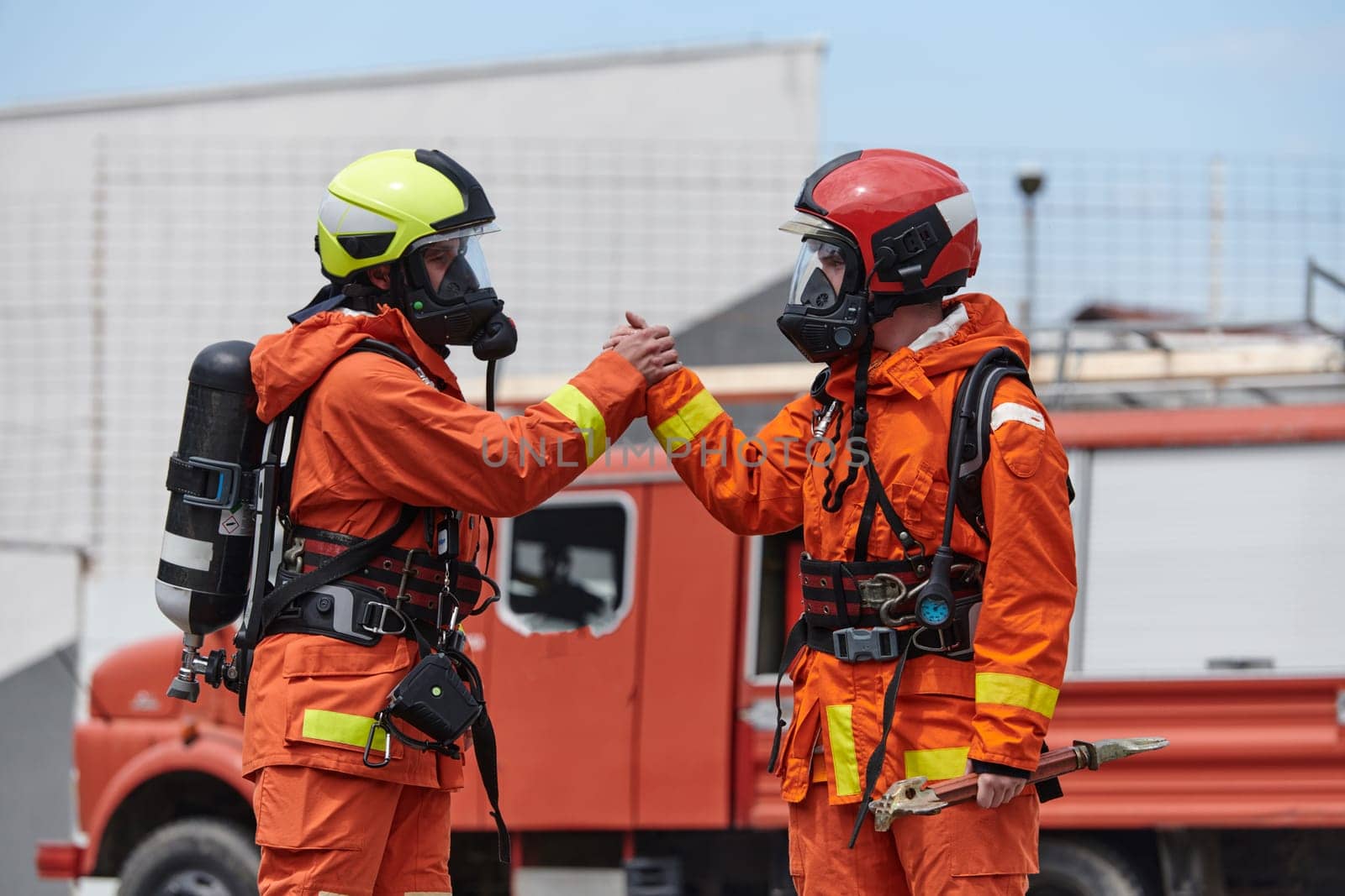 A unified team of firefighters, adorned in their uniforms, engages in a heartfelt celebration marked by triumphant salutes and cheers, embodying the joy and gratitude following the successful completion of a challenging firefighting mission.