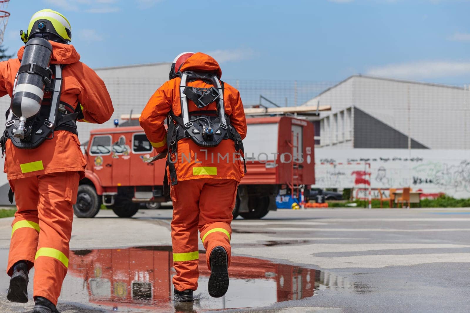 A team of firefighters, dressed in professional gear, undergoes training to learn how to use various firefighting tools and prepare for firefighting tasks.