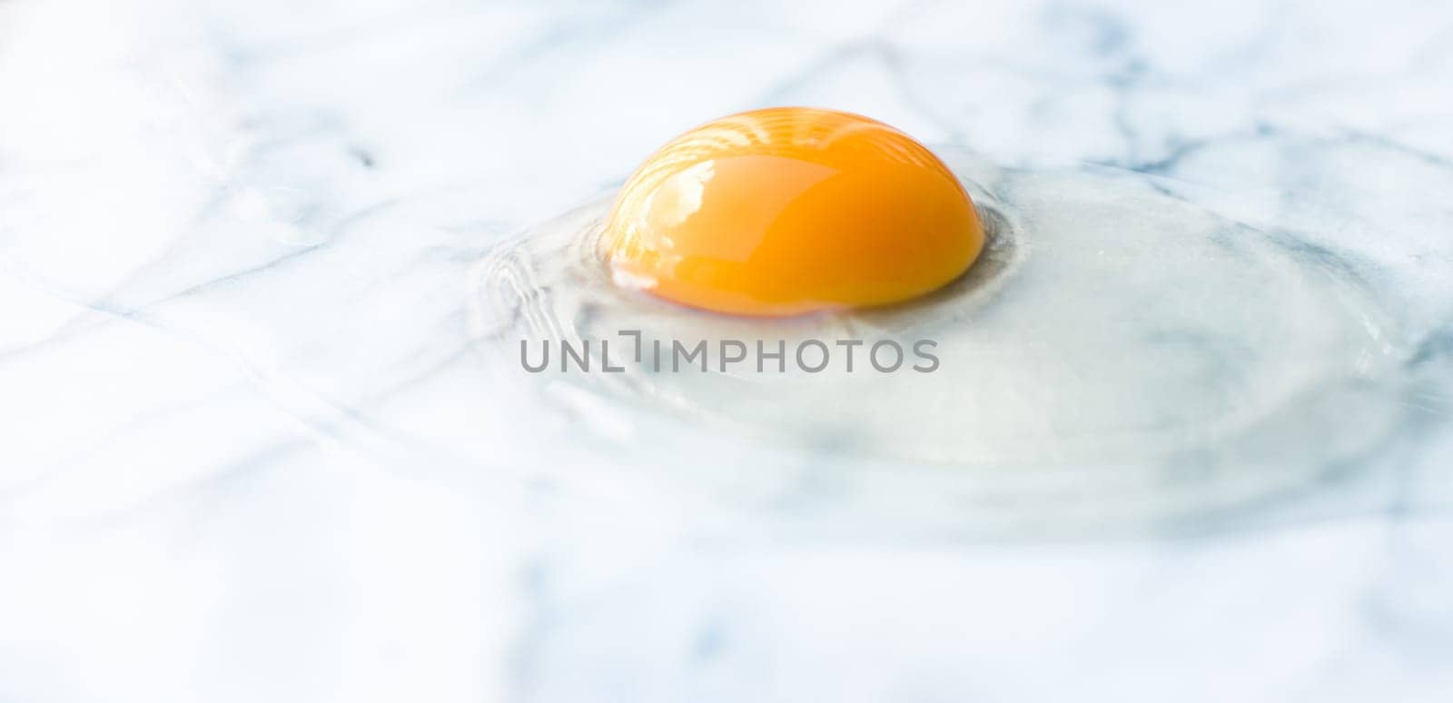 egg yolk on marble - recipe ingredients and homemade cooking styled concept