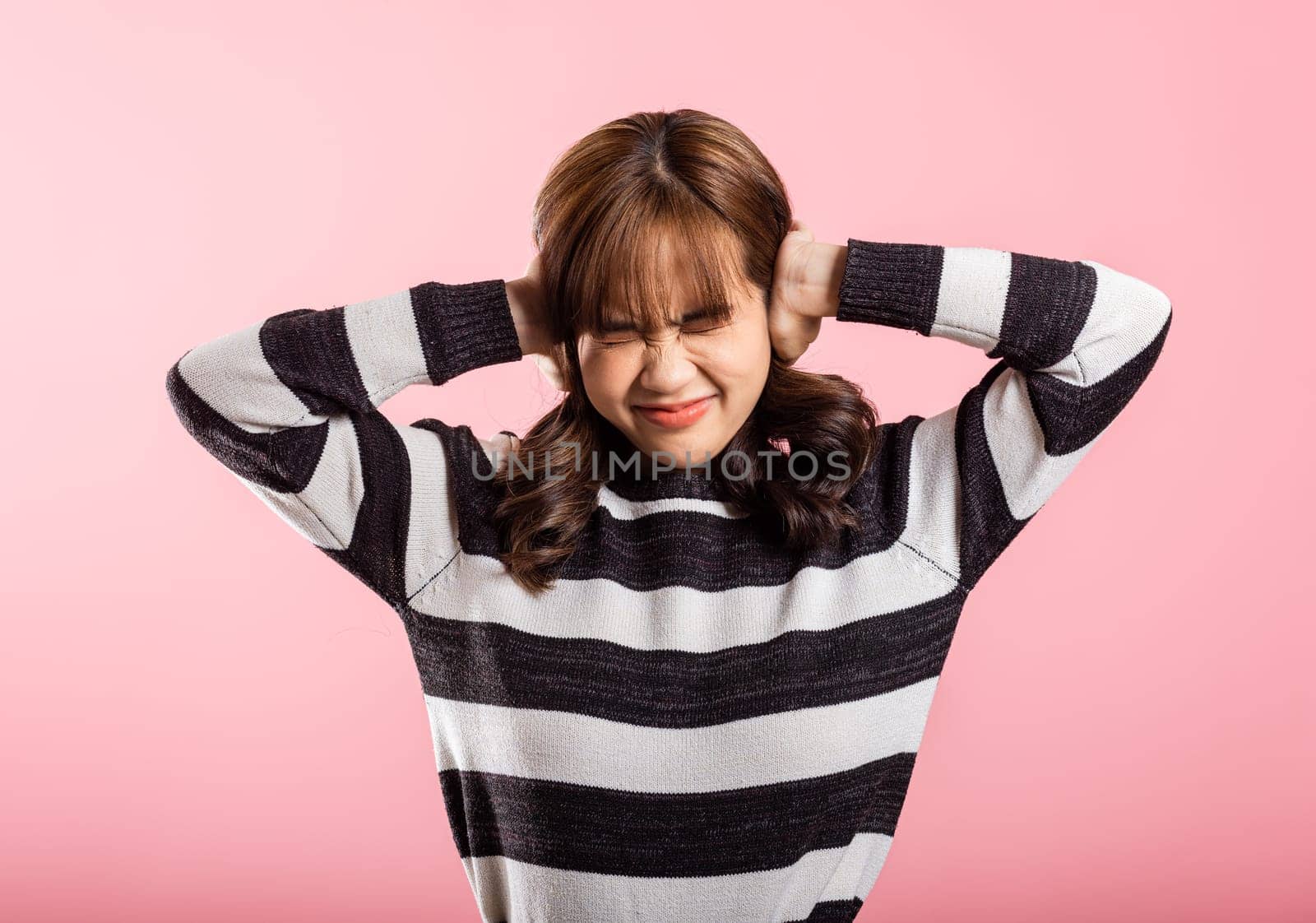 woman closed ears with hand palms and close eyes and shouting by Sorapop