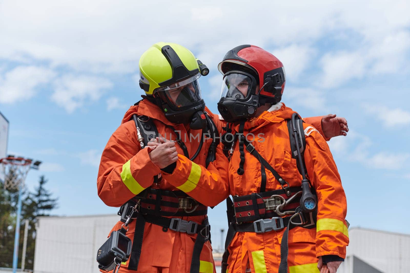 A unified team of firefighters, adorned in their uniforms, engages in a heartfelt celebration marked by triumphant salutes and cheers, embodying the joy and gratitude following the successful completion of a challenging firefighting mission.