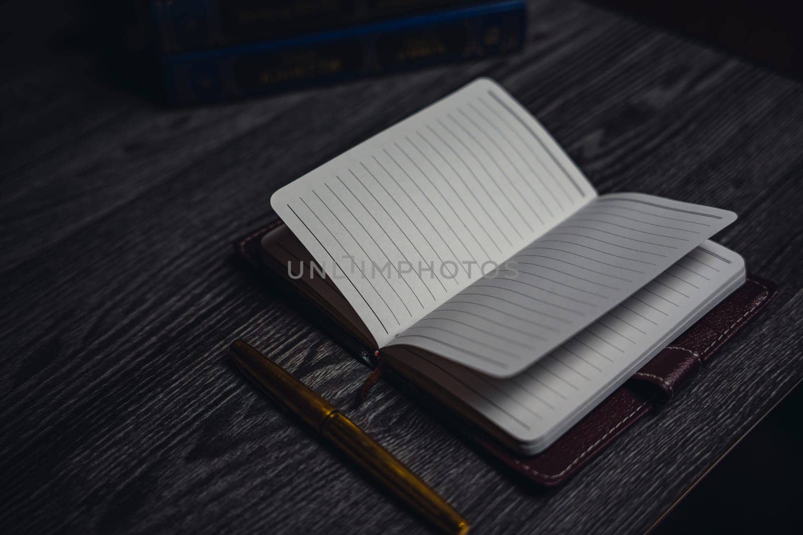 Notepad with pen on a wooden table. Business, finance and creativity. Workplace. High quality photo